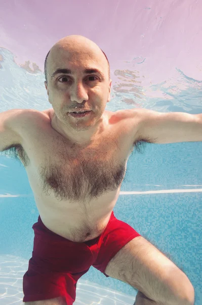 Undervatten porträtt av skallig man i en pool. — Stockfoto