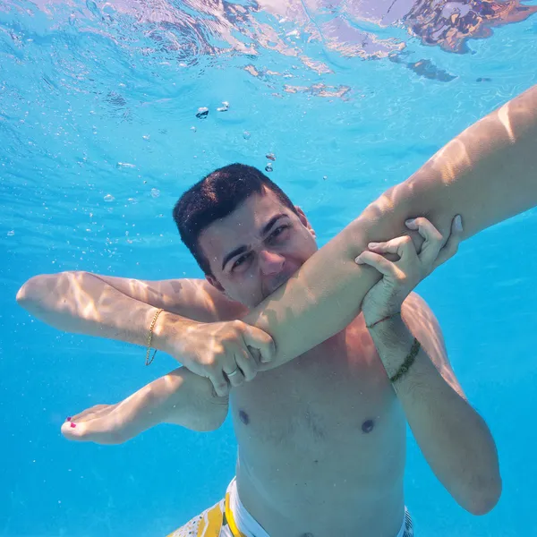 Víz alatti pár szórakozás úszómedencében. — Stock Fotó
