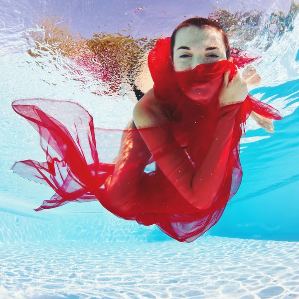 Unterwasser-Frauenmodeporträt mit rotem Schleier im Schwimmbad — Stockfoto