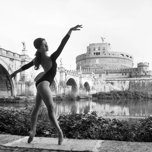 Joven hermosa bailarina bailando en la orilla del río Tevere con el castillo Santangelo en el fondo en Roma, Italia. Imagen en blanco y negro. Proyecto Bailarina . —  Fotos de Stock