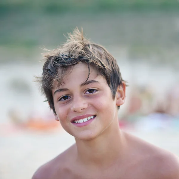 Ung pojke stående på stranden. — Stockfoto