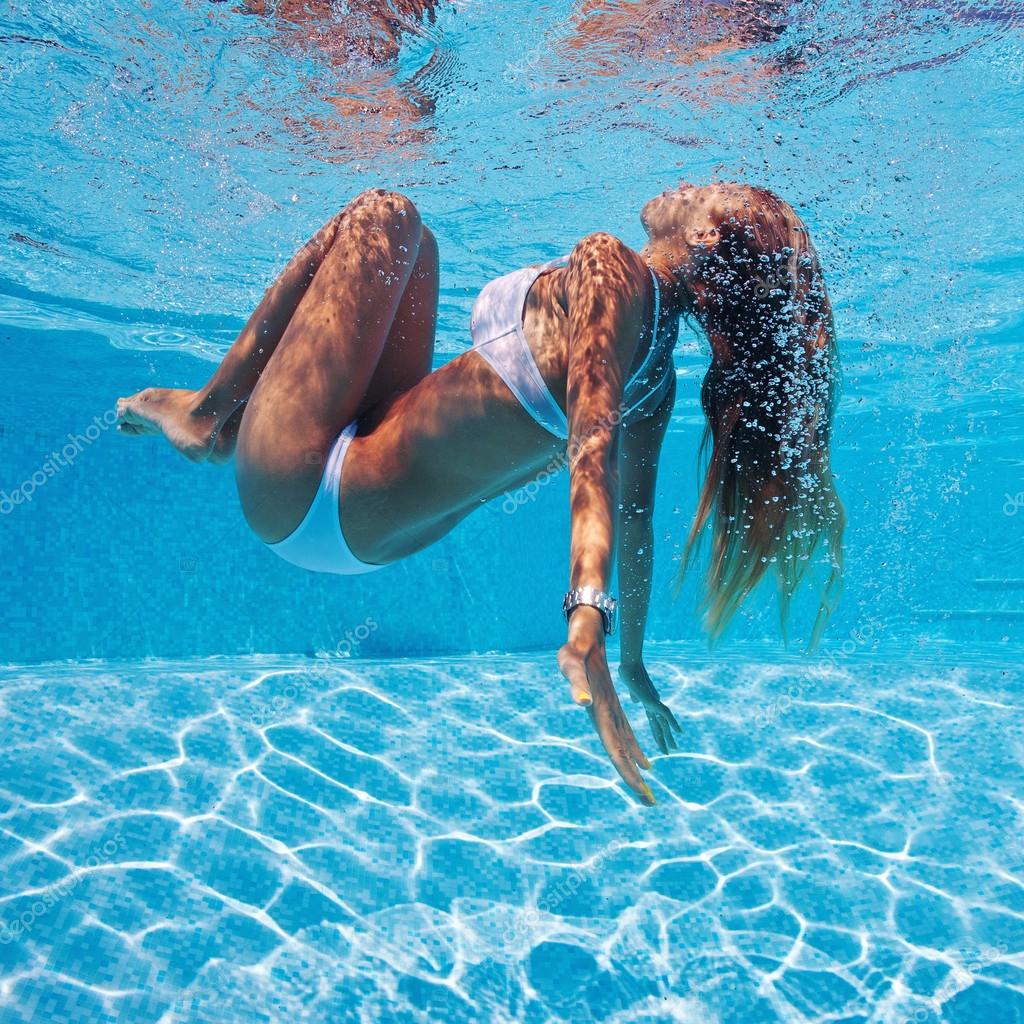 Underwater woman portrait with white bikini in swimming pool