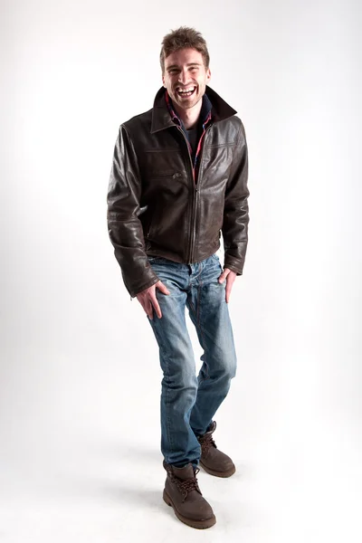 Portrait of young man laughing with leather jacket against white background — Stock Photo, Image