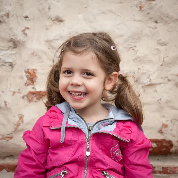 Weinig meisje portret tegen een muur — Stockfoto