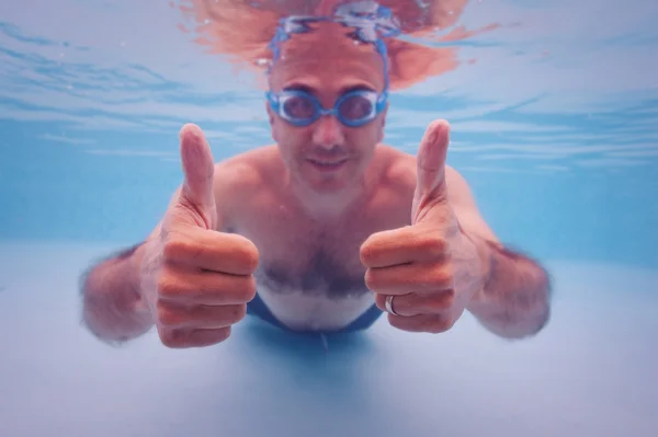 Retrato subaquático de um homem feliz numa piscina. DOF superficial — Fotografia de Stock