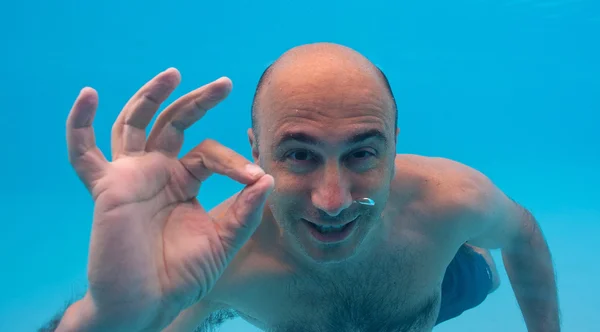 Retrato submarino de hombre con signo de ok en una piscina —  Fotos de Stock