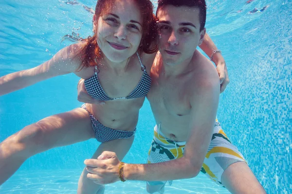 Pareja bajo el agua besándose en piscina —  Fotos de Stock