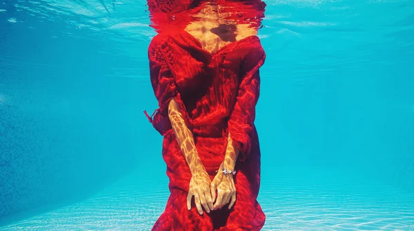 Podvodní žena s červenými šaty v bazénu — Stock fotografie