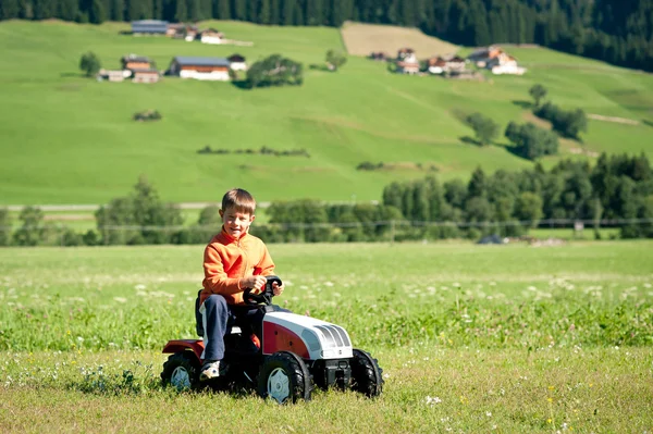 Niño jugando con tractor juguete al aire libre — Foto de Stock
