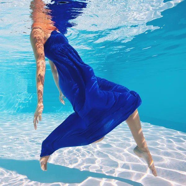 Retrato de mulher subaquática com vestido azul na piscina — Fotografia de Stock