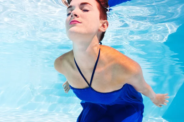 Retrato de mujer submarina con vestido azul en la piscina —  Fotos de Stock