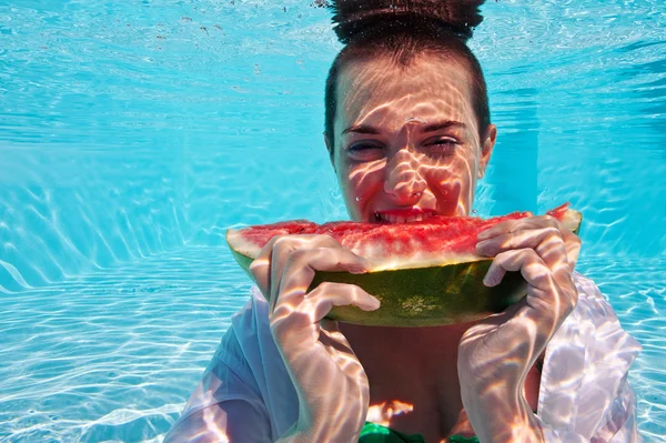 Unterwasserfrau isst eine Scheibe Wassermelone im Schwimmbad — Stockfoto