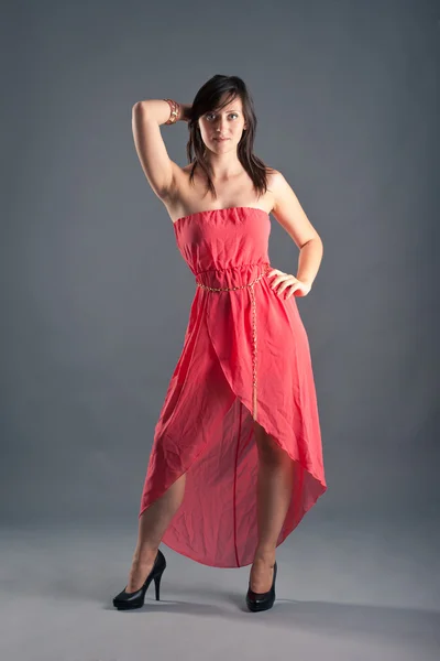 Mulher bonita em vestido vermelho no fundo escuro — Fotografia de Stock