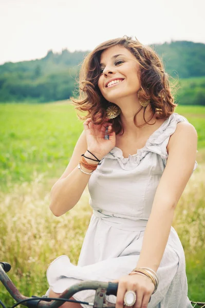 Beautiful young woman portrait with bike in a country road — Stock Photo, Image