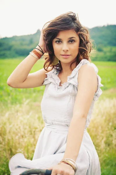 Beautiful young woman portrait with bike in a country road — Stock Photo, Image