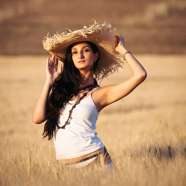 Joven mujer sexy en un campo de trigo con vestido blanco y sombrero de paja —  Fotos de Stock