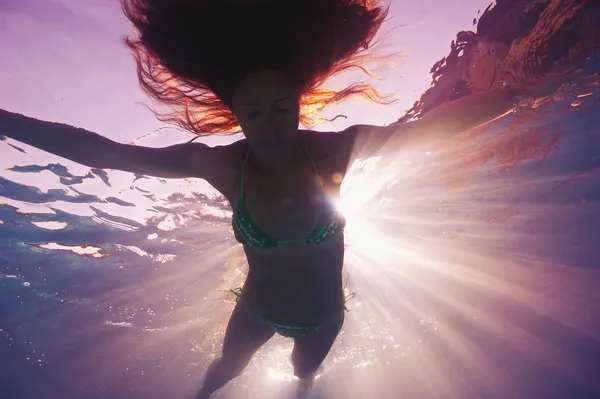 Silueta de mujer bajo el agua en la piscina con luz de fondo —  Fotos de Stock
