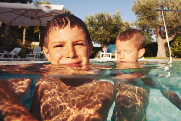 Dois irmãos pequenos brincando em uma piscina — Fotografia de Stock