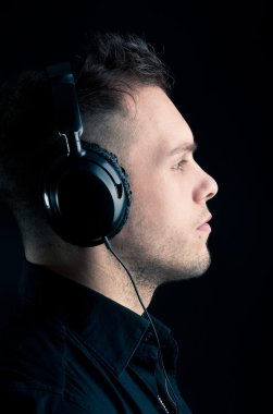 profil adamın kulak-telefonlarıyla siyah arka plan üzerine kapatın