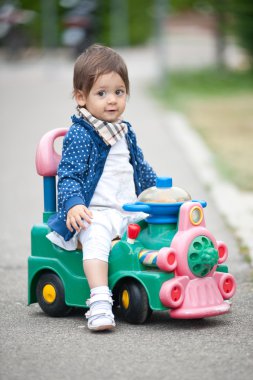 Tren oyuncak üzerinde açık oynayan bir yaşında bir kız