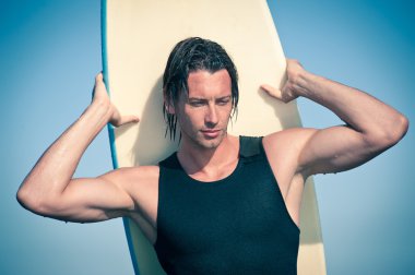 çekici genç adam portresi bir surfboard ile plajda sörf