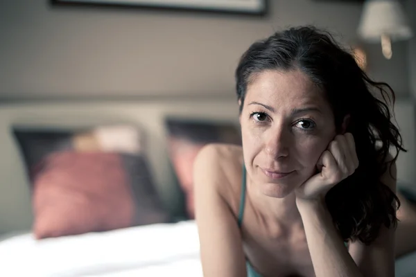 Porträt einer sinnlichen Frau, die im Hotelzimmer auf dem Bett liegt. geringe Schärfentiefe — Stockfoto