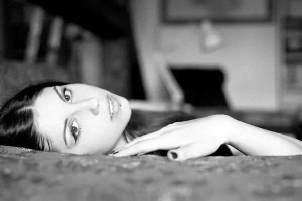 Portrait of a sensual young woman lying on sofa. Black and white — Stock Photo, Image