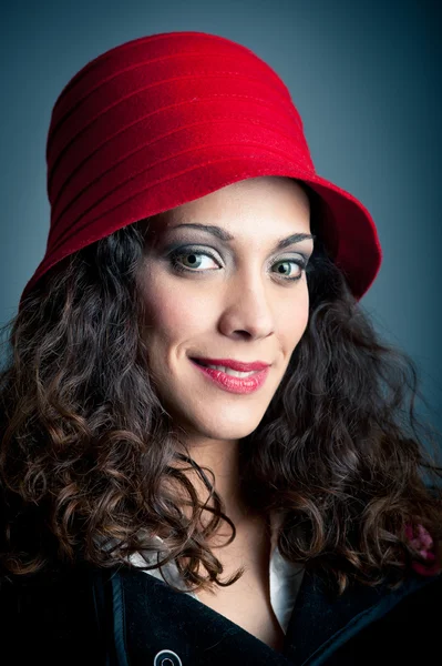Mooie vrouw in de rode hoed tegen zwarte achtergrond. Retro portret — Stockfoto