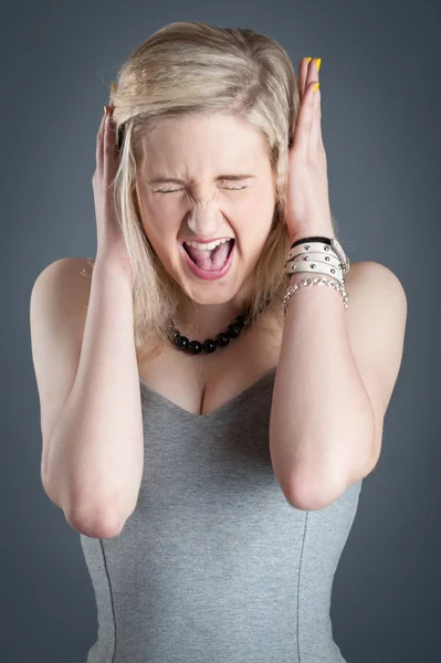 Retrato de gritando desesperada rubia adolescente sobre fondo oscuro —  Fotos de Stock