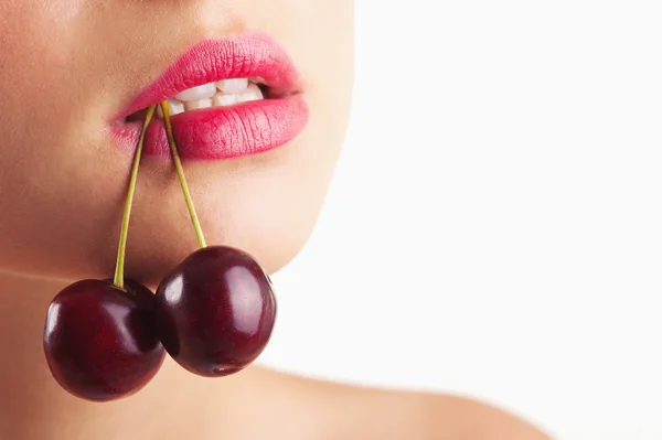 Close up portrait of beautiful young woman with cherry against white background — Stock Photo, Image