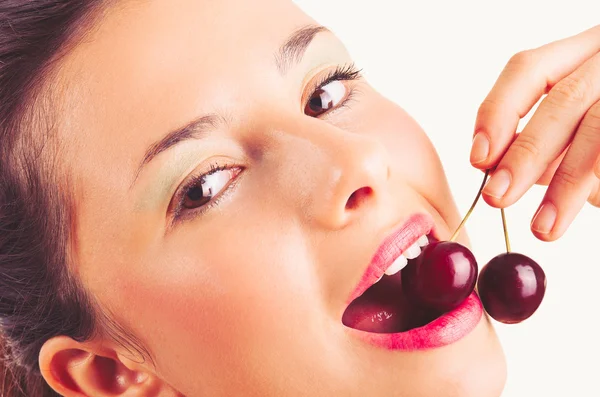 Close-up van portret van mooie jonge vrouw met cherry tegen witte achtergrond — Stockfoto