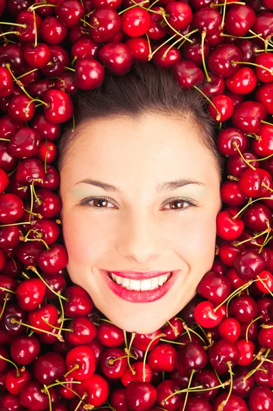 Jovem mulher sorridente rosto retrato cercado por cerejas — Fotografia de Stock