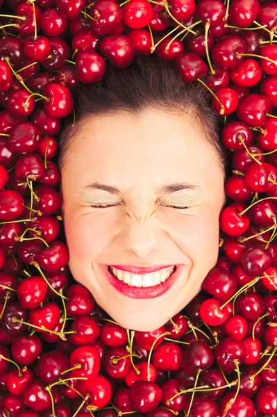 Young woman smiling face portrait surrounded by cherries — Stockfoto