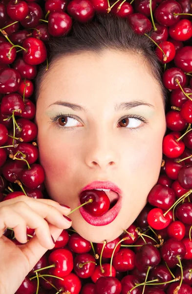 Young woman face portrait surrounded by cherries — Stockfoto