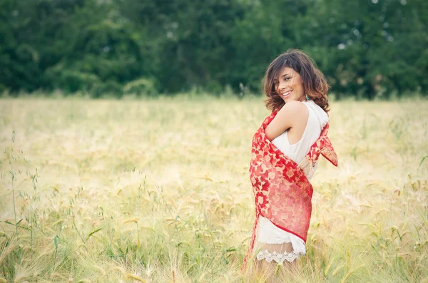 Portrait of charming young girl with red fabric — Stock Photo, Image