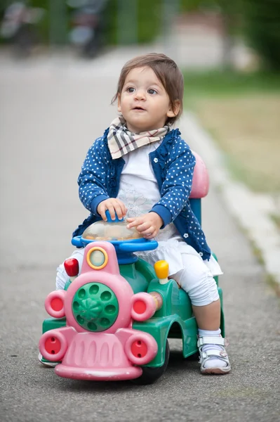 Één jaar oud meisje en buiten spelen op trein speelgoed — Stockfoto