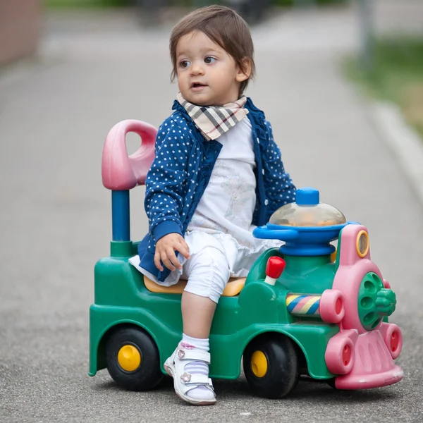 Één jaar oud meisje en buiten spelen op trein speelgoed — Stockfoto