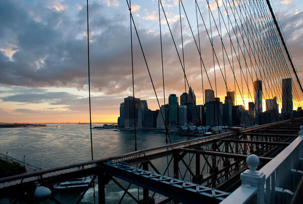 Panoramic shot of Manhattan skyline and Liberty island from the Brooklyn bridge