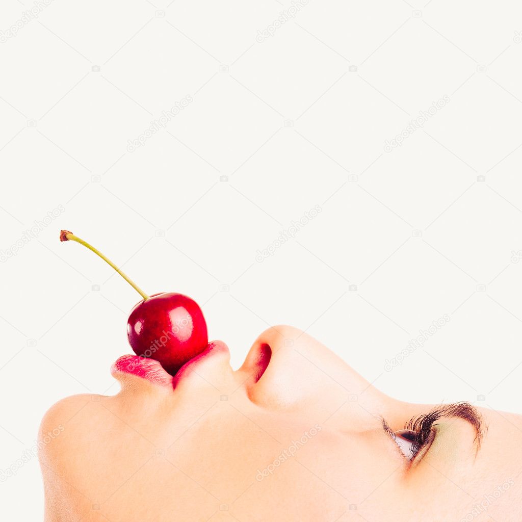 Close up portrait of beautiful young woman with cherry against white background