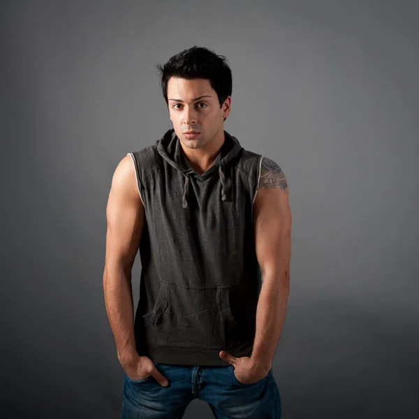 Portrait of young muscle man on dark background — Stock Photo, Image