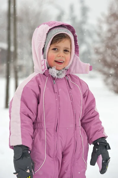 Portrait de bébé fille avec costume de ski rose dans la neige — Photo