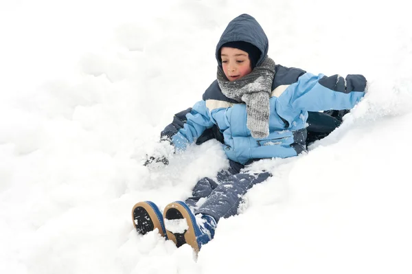 Joven chico divirtiéndose deslizándose en la nieve — Foto de Stock