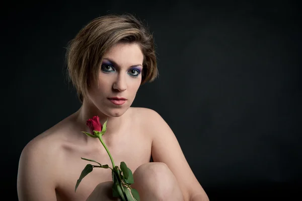 Retrato de hermosa chica con flor de rosa sobre fondo negro — Foto de Stock