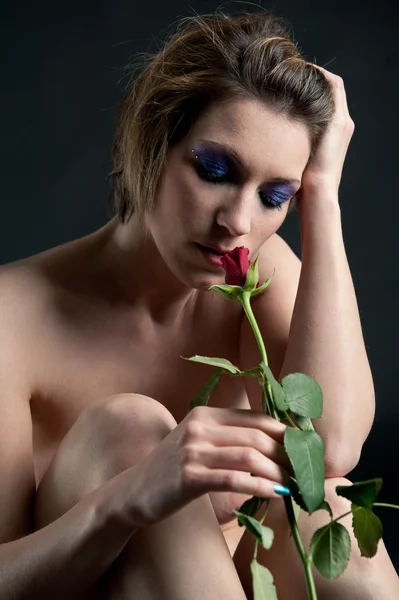 Retrato de menina bonita com flor de rosa contra fundo preto — Fotografia de Stock