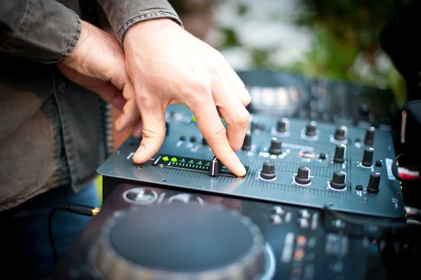 Jovem trabalhando como DJ com misturador. Foco superficial nas mãos — Fotografia de Stock