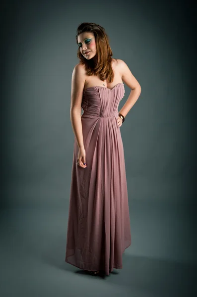 Portrait of beautiful girl with pink dress against dark background — Stock Photo, Image