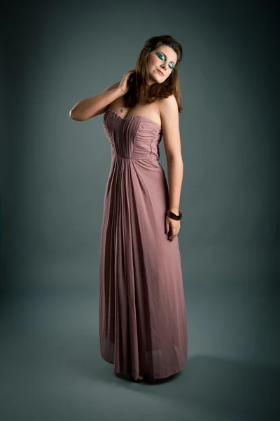 Retrato de menina bonita com vestido rosa contra fundo escuro — Fotografia de Stock