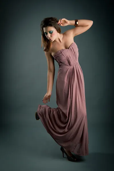 Retrato de menina bonita com vestido rosa contra fundo escuro — Fotografia de Stock