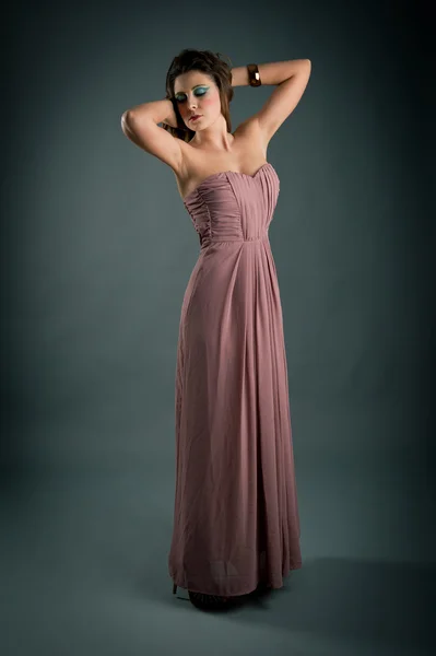 Retrato de menina bonita com vestido rosa contra fundo escuro — Fotografia de Stock