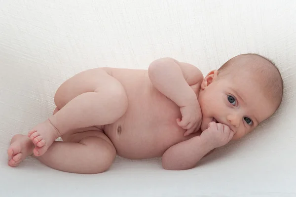 Bebê recém-nascido em um fundo branco. Pendurado em funda de algodão — Fotografia de Stock